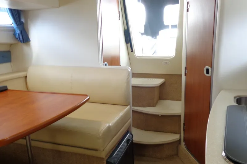 Slide: The Image of Interior of 2007 Bayliner 285 boat with seating, table, and stairs. - 33
