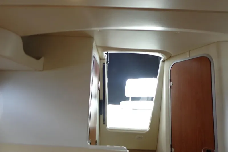 Slide: The Image of Interior view of a 2007 Bayliner 285 boat, featuring a doorway and seating area. - 34