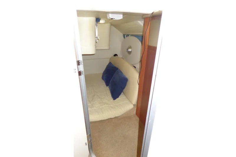Slide: The Image of Interior cabin of 2007 Bayliner 285 boat with cozy bedding and blue pillows. - 37