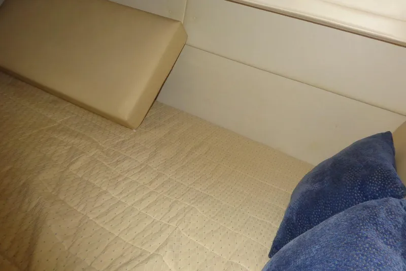 Slide: The Image of Interior cabin of 2007 Bayliner 285 with beige bedding and blue pillows. - 38