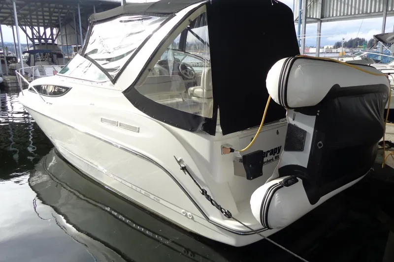 Slide: The Image of 2007 Bayliner 285 boat docked in marina, featuring covered cockpit and inflatable fenders. - 4