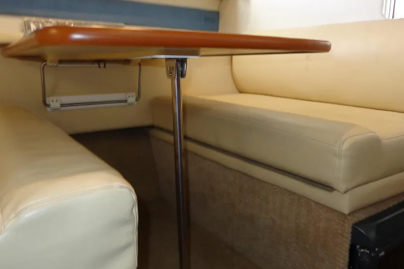Slide: The Image of Interior seating area of a 2007 Bayliner 285 boat with beige cushions and wooden table. - 41