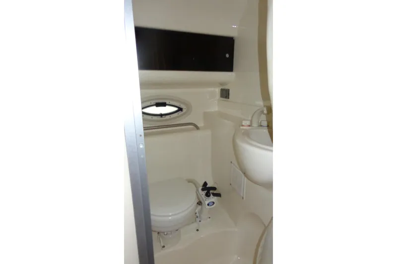 Slide: The Image of 2007 Bayliner 285 boat bathroom with toilet, sink, and porthole window. - 42