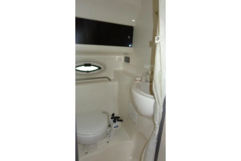 Slide: The Image of 2007 Bayliner 285 boat bathroom interior with sink, toilet, and porthole window. - 44