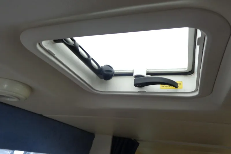 Slide: The Image of Open hatch window inside 2007 Bayliner 285 boat cabin, showing handle and latch mechanism. - 45