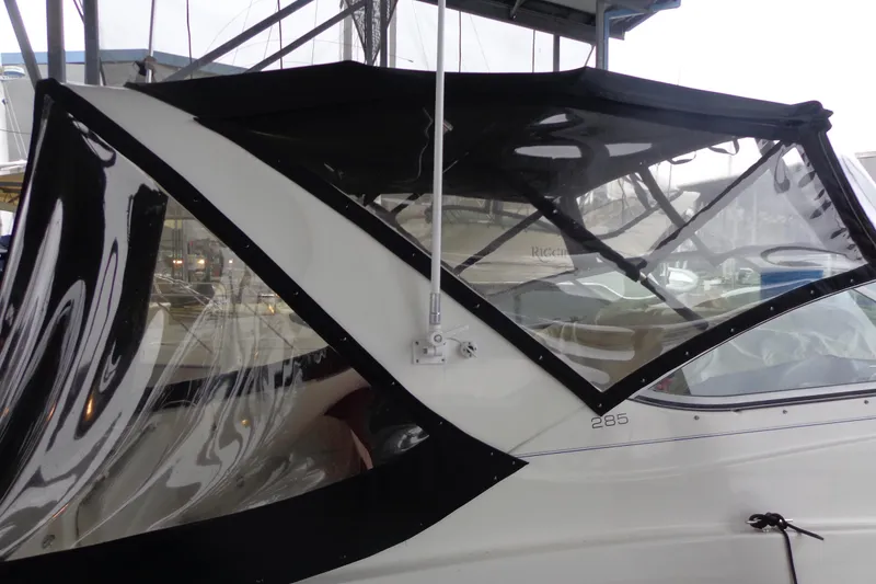 Slide: The Image of 2007 Bayliner 285 boat with black canopy and clear windows in marina setting. - 6