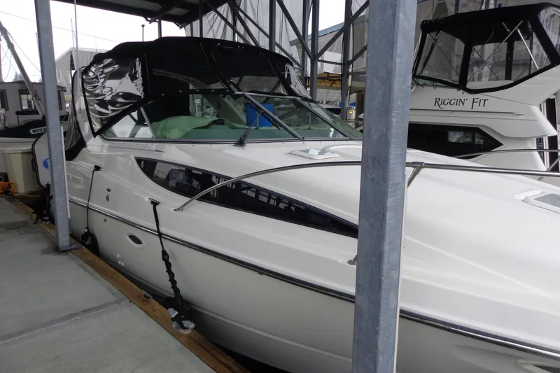 Slide: The Image of 2007 Bayliner 285 boat docked in a marina, featuring sleek design and covered cockpit. - 8