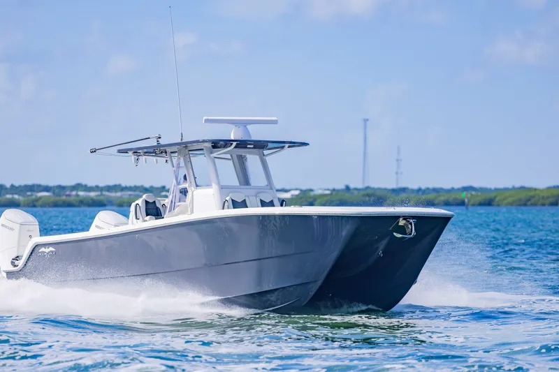 Slide: The Image of 2023 Invincible 35 Catamaran cruising on open water, showcasing sleek design and performance. - 13