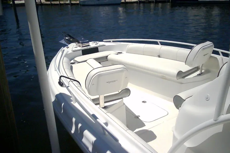 Slide: The Image of 2021 Glasstream 240 CCX boat with white seating, docked on calm water. - 11