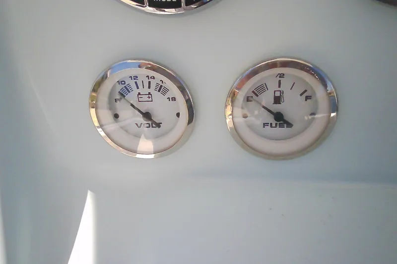 Slide: The Image of Volt and fuel gauges on a 2021 Glasstream 240 CCX boat dashboard. - 24