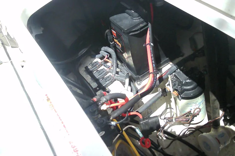 Slide: The Image of 2021 Glasstream 240 CCX boat battery compartment with wiring and components. - 42