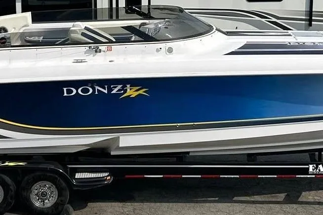 The Image of 2001 Donzi speedboat with blue and white design on a trailer. - 1
