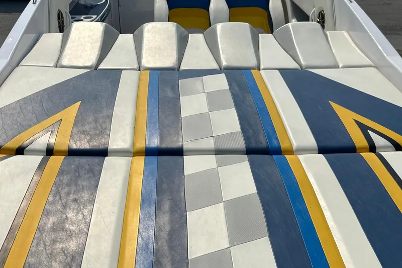 Slide: The Image of 2001 Donzi boat interior with colorful, geometric-patterned upholstery in blue, yellow, and white. - 11
