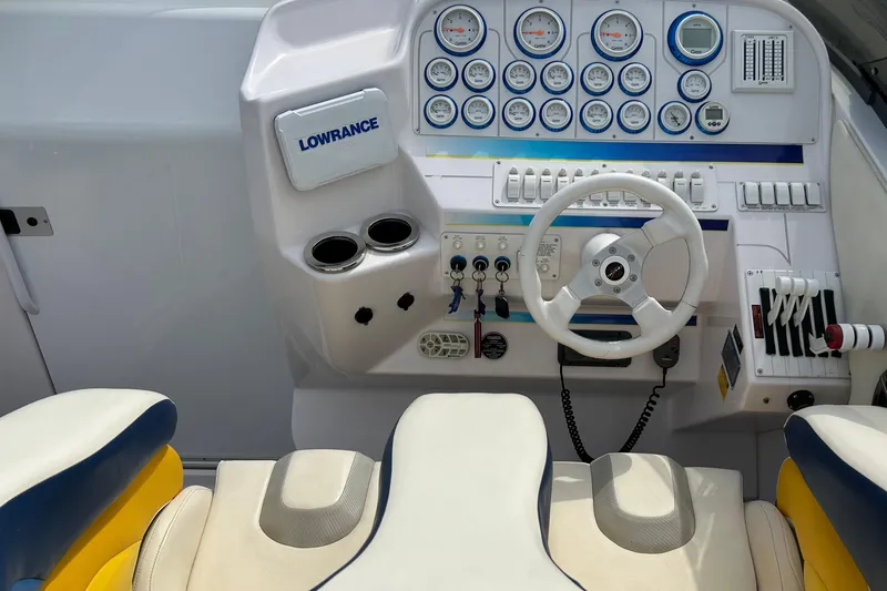 Slide: The Image of 2001 Donzi boat dashboard with steering wheel, gauges, and controls. - 13