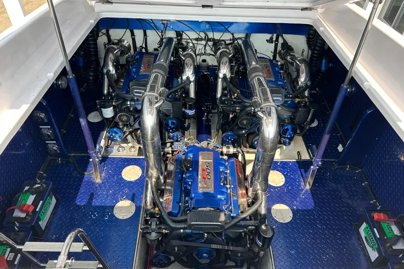 Slide: The Image of Engine compartment of a 2001 Donzi boat featuring powerful blue engines and polished components. - 24