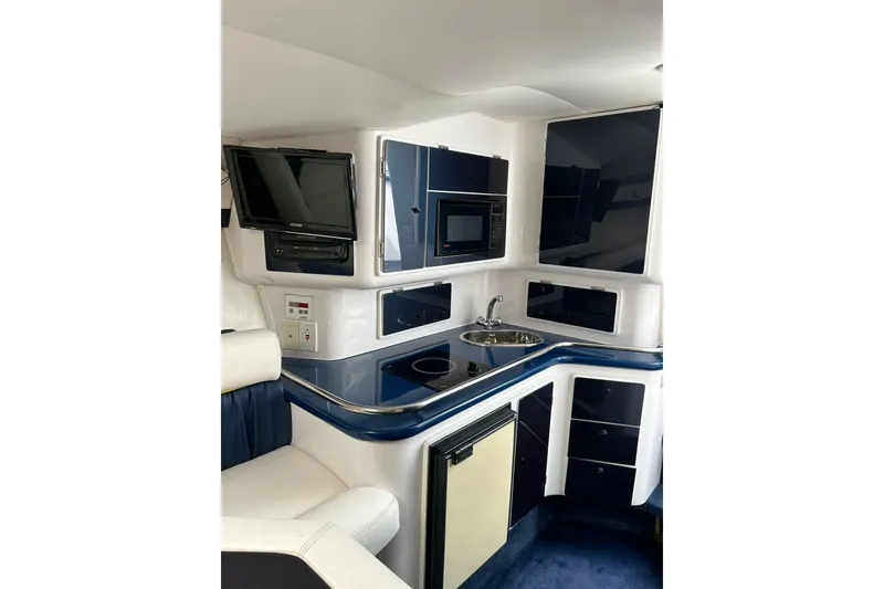 Slide: The Image of Interior of a 2001 Donzi boat featuring a compact kitchen with modern amenities. - 33