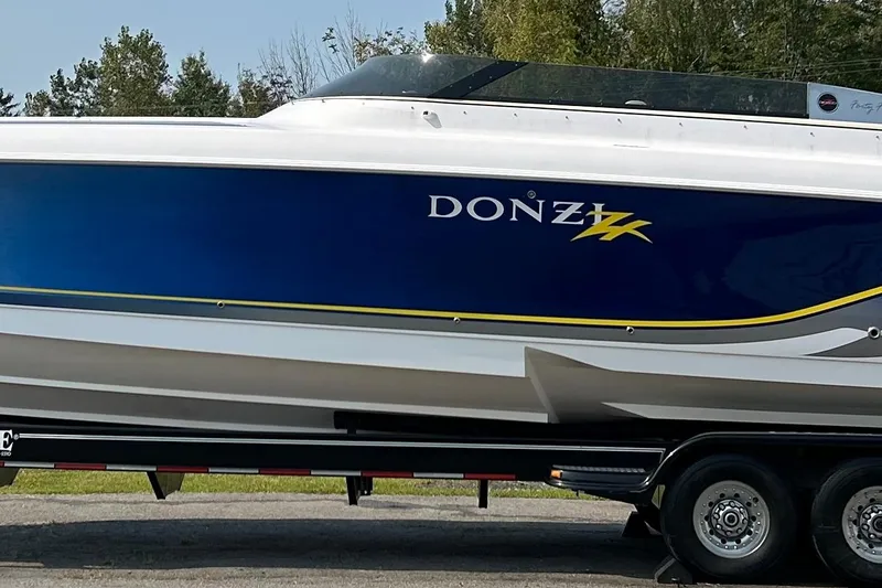 Slide: The Image of 2001 Donzi boat on trailer, blue and white design with yellow accents. - 4