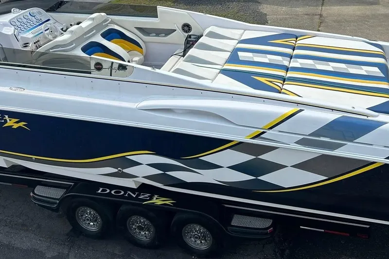 Slide: The Image of 2001 Donzi boat with vibrant blue and yellow racing graphics on a trailer. - 5