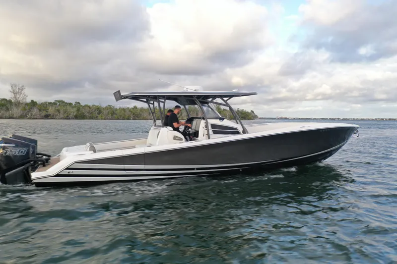 Slide: The Image of 2021 Nor-Tech 390 Sport Center Console boat cruising on water under cloudy sky. - 1