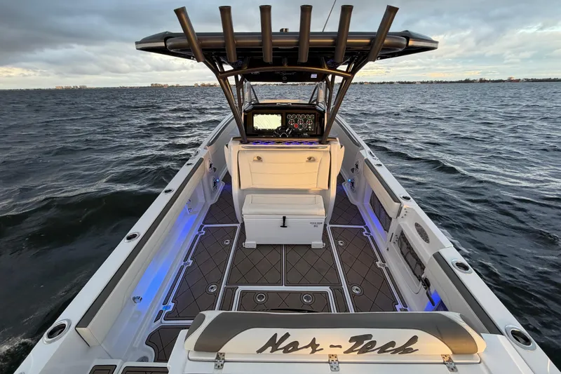 Slide: The Image of 2021 Nor-Tech 390 Sport Center Console boat on open water, featuring sleek design and advanced controls. - 17