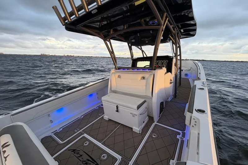 Slide: The Image of 2021 Nor-Tech 390 Sport Center Console boat on open water, featuring sleek design and modern amenities. - 18