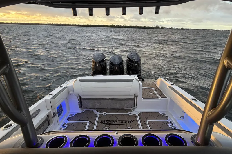 Slide: The Image of 2021 Nor-Tech 390 Sport Center Console boat with triple engines on open water. - 19