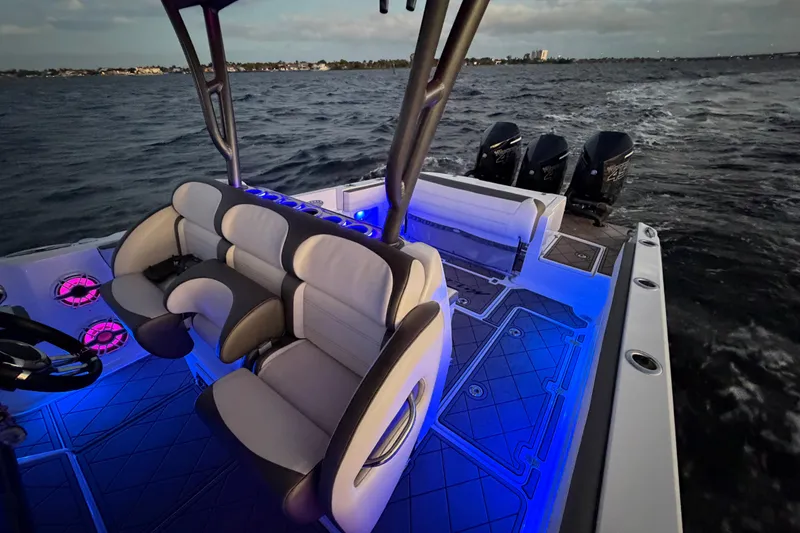 Slide: The Image of 2021 Nor-Tech 390 Sport Center Console with illuminated seating and triple engines on open water. - 23