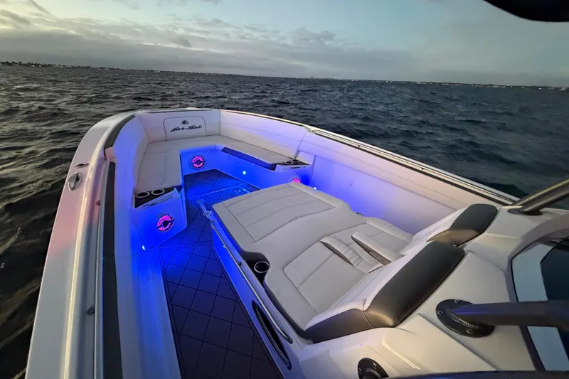 Slide: The Image of 2021 Nor-Tech 390 Sport Center Console boat with illuminated seating at dusk on the water. - 24