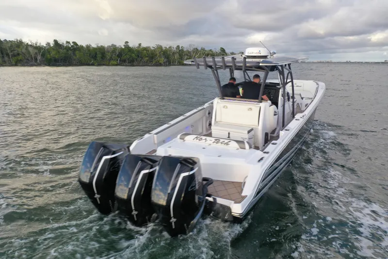 Slide: The Image of 2021 Nor-Tech 390 Sport Center Console boat cruising on water with four engines. - 4