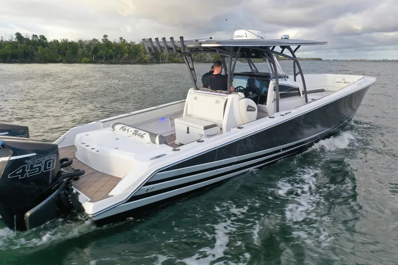Slide: The Image of 2021 Nor-Tech 390 Sport Center Console boat cruising on water, featuring powerful engines. - 7