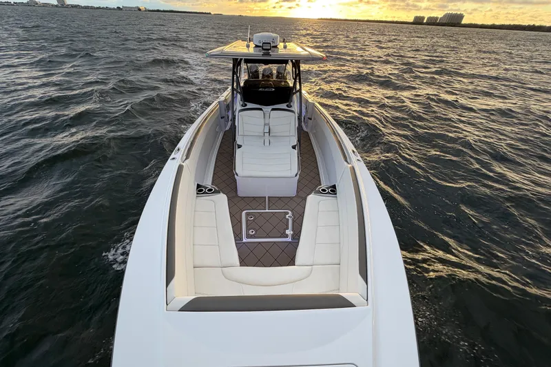 Slide: The Image of 2021 Nor-Tech 390 Sport Center Console boat cruising at sunset on open water. - 8