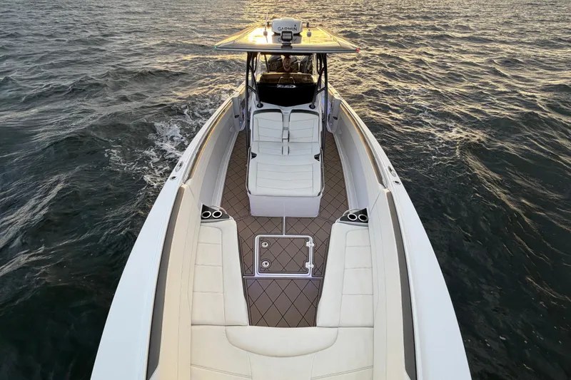 Slide: The Image of 2021 Nor-Tech 390 Sport Center Console boat cruising on open water at sunset. - 9