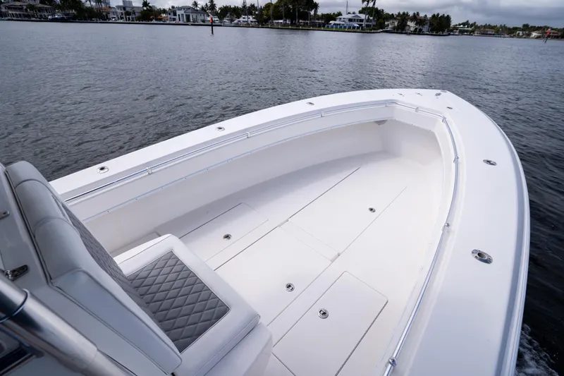 Slide: The Image of 2014 Contender 35 ST boat on calm water, featuring spacious deck and seating. - 13