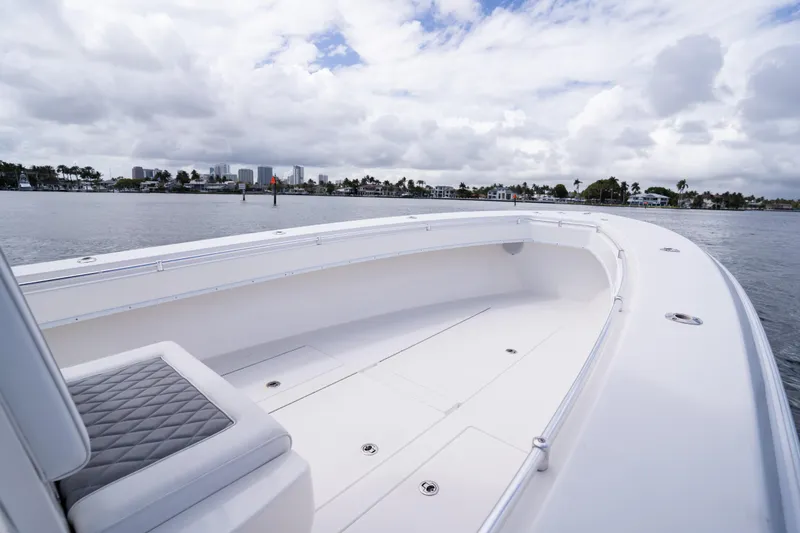 Slide: The Image of 2014 Contender 35 ST boat on calm water with cloudy sky and distant shoreline. - 14