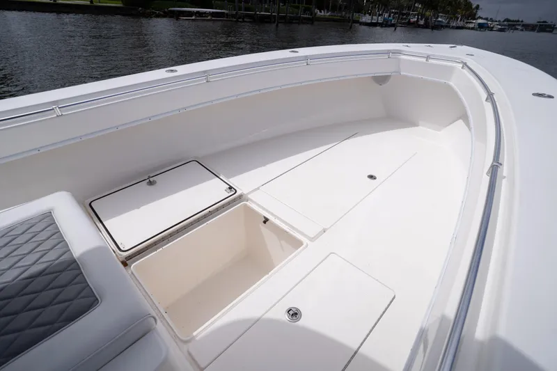 Slide: The Image of 2014 Contender 35 ST boat deck with storage compartments and seating, docked by the water. - 16