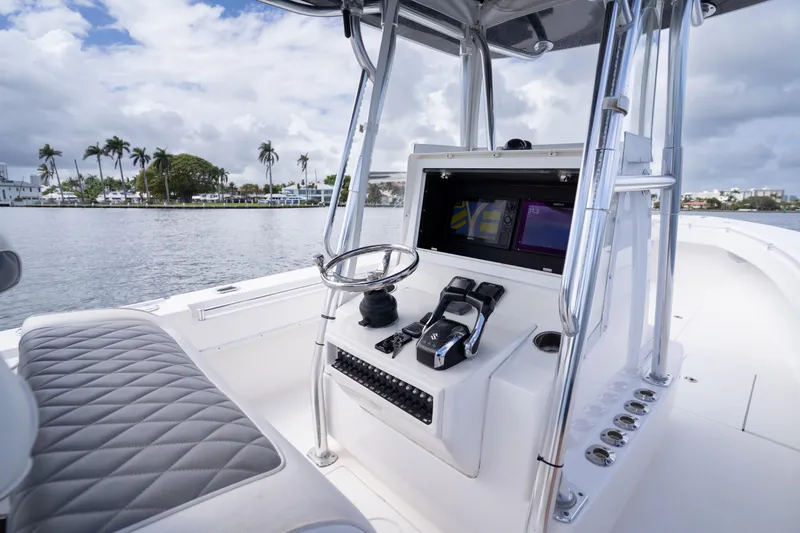 Slide: The Image of 2014 Contender 35 ST boat cockpit with steering wheel and control panel on a sunny day. - 23