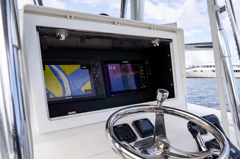 Slide: The Image of 2014 Contender 35 ST boat dashboard with Garmin and Simrad navigation displays. - 25