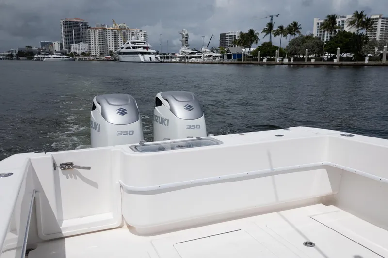 Slide: The Image of 2014 Contender 35 ST boat with twin Suzuki 350 engines, docked near city skyline. - 30