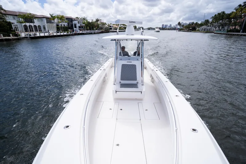 Slide: The Image of 2014 Contender 35 ST boat cruising on a scenic waterway with luxury homes. - 31