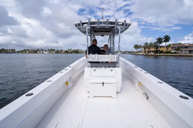 Slide: The Image of 2014 Contender 35 ST boat cruising on a scenic waterway under a cloudy sky. - 33