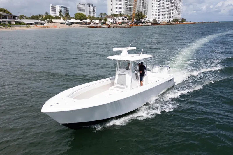 Slide: The Image of 2014 Contender 35 ST boat cruising near a coastal city skyline. - 6