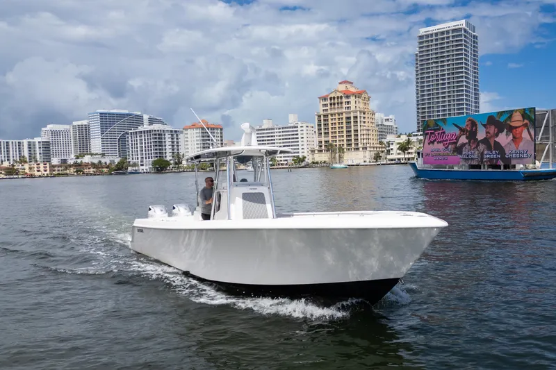 Slide: The Image of 2014 Contender 35 ST boat cruising near city skyline and waterfront billboard. - 8