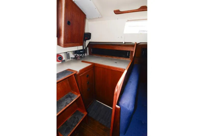 Slide: The Image of Interior of 1980 C&C 30 Mk I sailboat with wooden cabinetry and blue seating. - 10