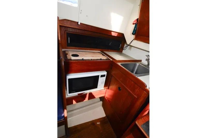 Slide: The Image of Compact galley kitchen in 1980 C&C 30 Mk I sailboat with microwave and sink. - 11