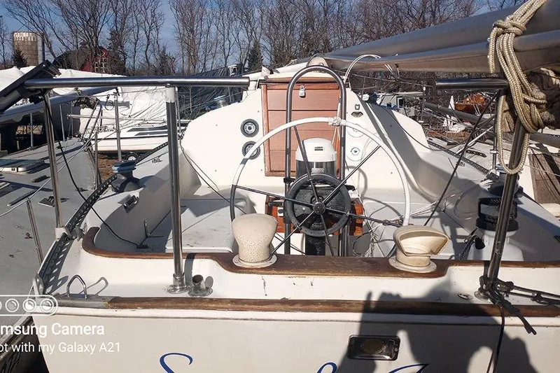 Slide: The Image of 1980 C&C 30 Mk I sailboat cockpit with steering wheel and winches, docked outdoors. - 4