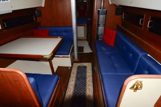 Slide: The Image of Interior of a 1980 C&C 30 Mk I sailboat with blue seating and wooden finishes. - 6