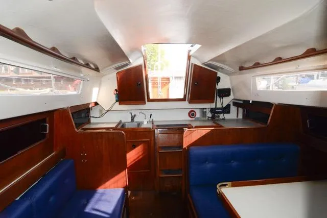 Slide: The Image of Interior of 1980 C&C 30 Mk I sailboat with wood finish and blue seating. - 7