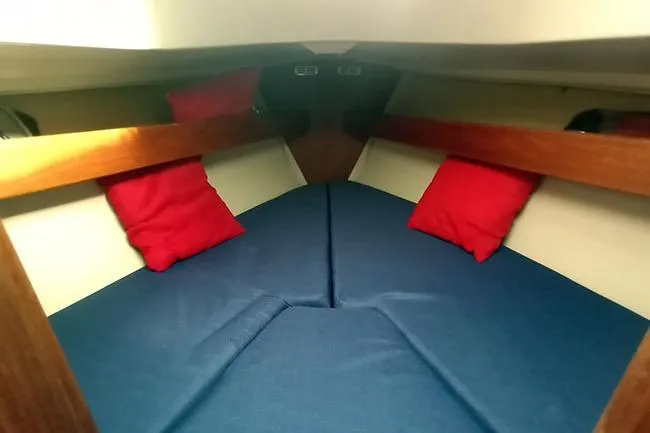 Slide: The Image of Interior of 1980 C&C 30 Mk I sailboat with blue cushions and red pillows. - 9