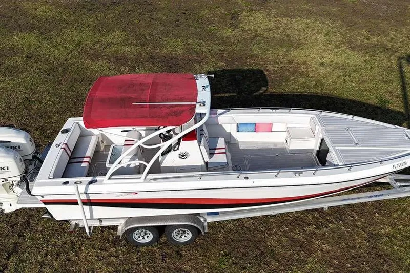 Slide: The Image of 1992 Baja 280 Sportfish boat on trailer, red canopy, dual engines, grassy background. - 3