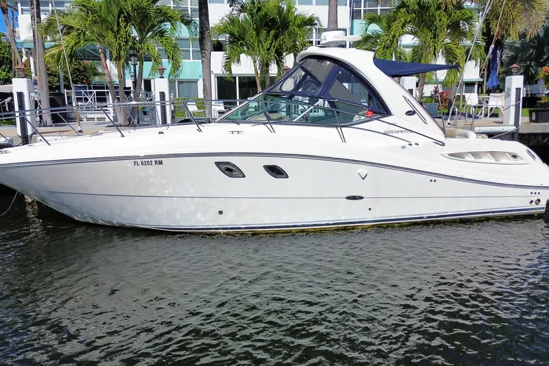 Slide: The Image of 2008 Sea Ray Sundancer 330 yacht docked by palm trees, reflecting on water. - 2